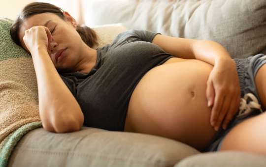pregnant woman laying on couch