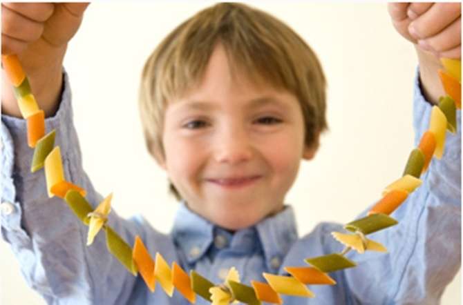 Kid holding macaroni necklace craft