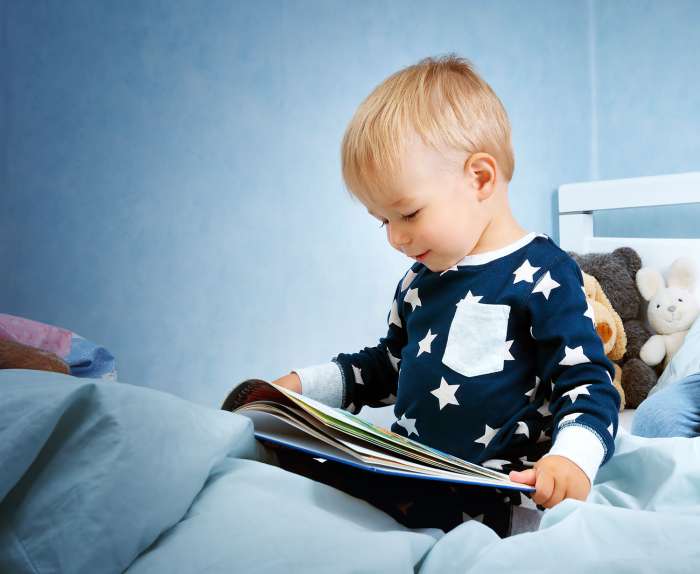 Child reading a book for hanukkah