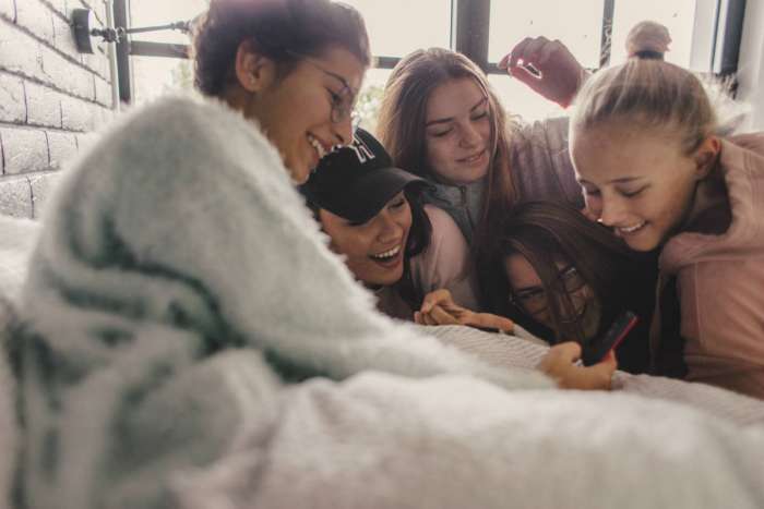 group of teen girls looking at phone at tiktok