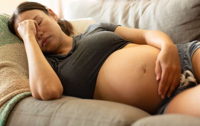 pregnant woman laying on couch