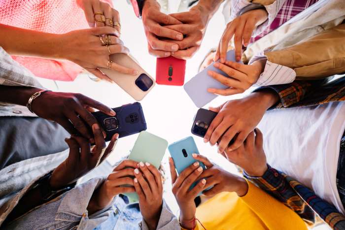 teenagers in a circle holding phones