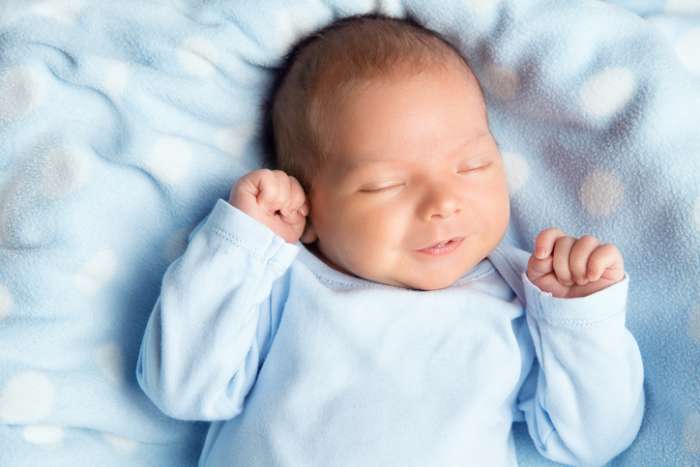 baby in blue on blanket