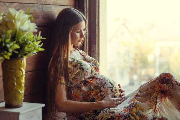 pregnant woman sitting in window