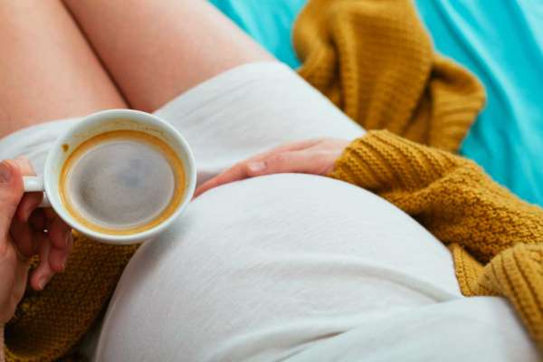 pregnant belly and cup of coffee