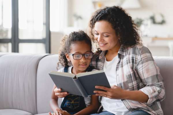 African American mom reading a book to her daughter