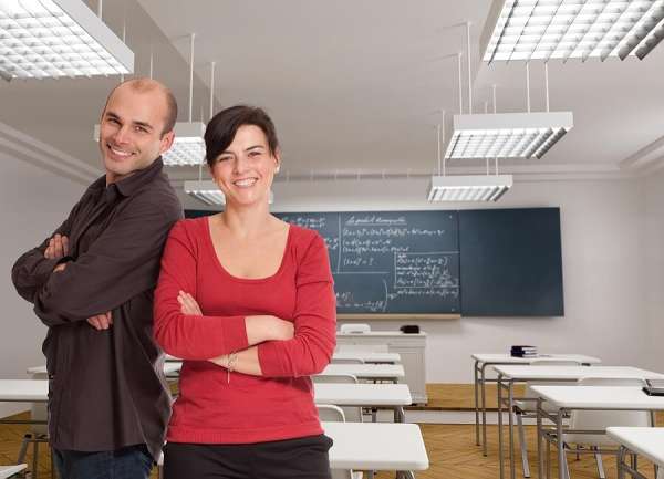 Parent and teacher sitting together in classroom