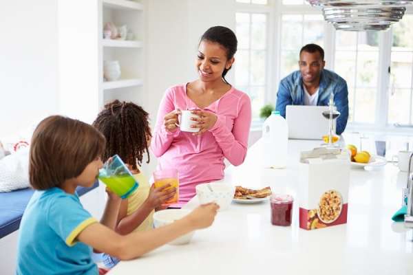 Family routine eating breakfast in kitchen