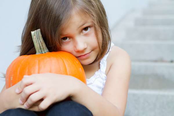 scared child with Halloween pumpkin