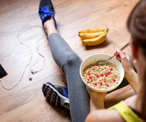 Young girl eating a oatmeal with berries after a workout 