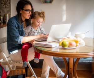 mom working on side hustle at home with toddler