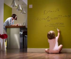 Successful baby doing algebra on hallway wall