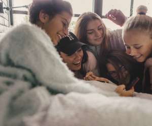 group of teen girls looking at phone at tiktok
