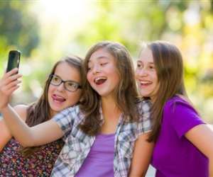 tween girls taking selfie with smartphone