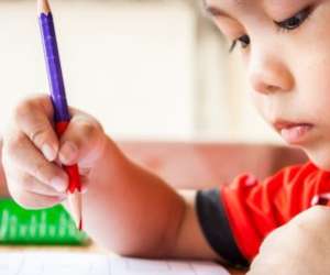 Preschool boy holding red pencil