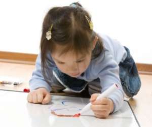Young girl on floor painting picture