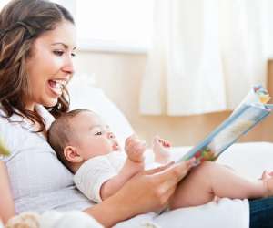 mom reading aloud to newborn baby
